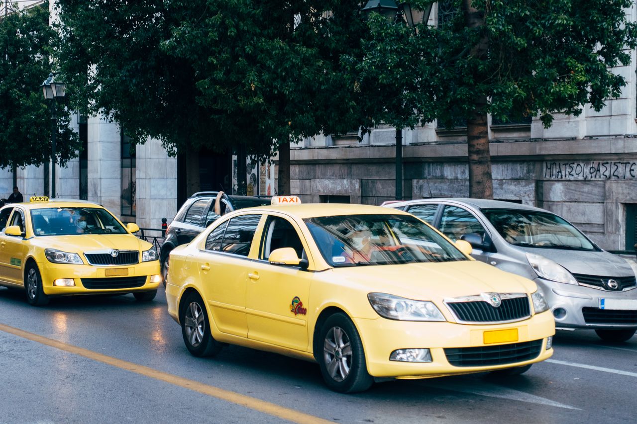 services-03 Yellow taxis lining the street in Athens, Greece, showcasing city's bustling transportation.